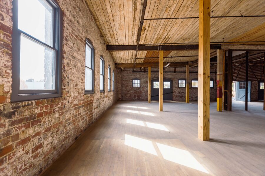 large open room with exposed brick and wooden beams