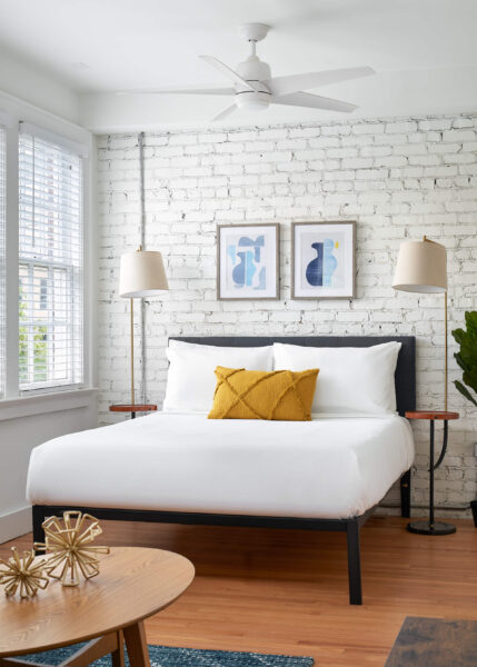 bedroom with painted exposed brick