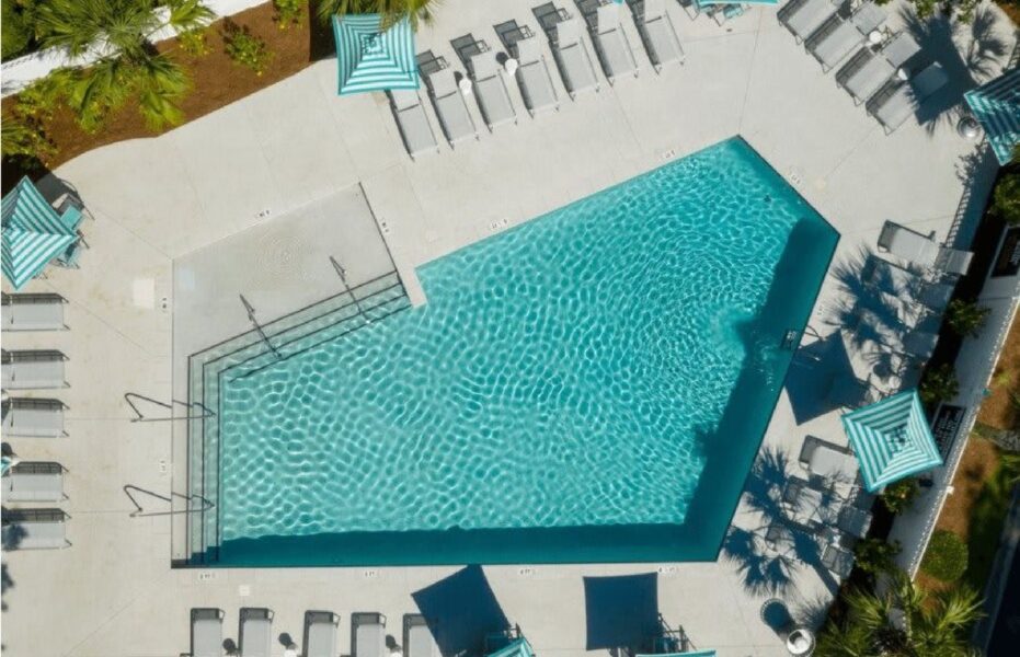 a large swimming pool with lounge chairs next to it