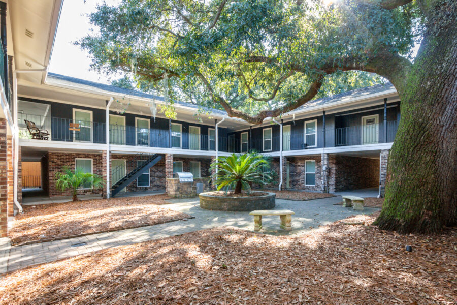 exterior of Apartment building with large trees beside it