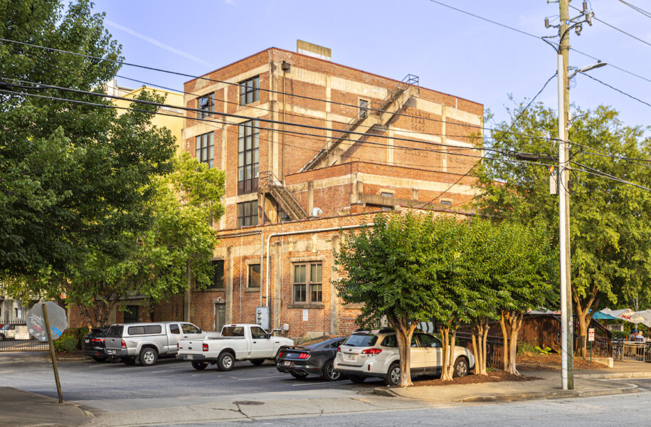 large brick apartment building surrounded by trees