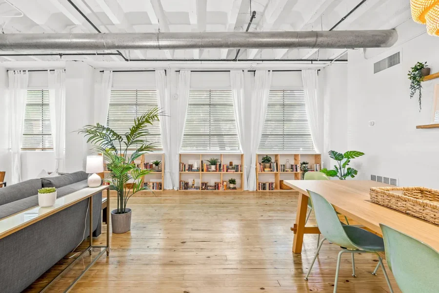 open room with wood floors and bookshelves by the windows