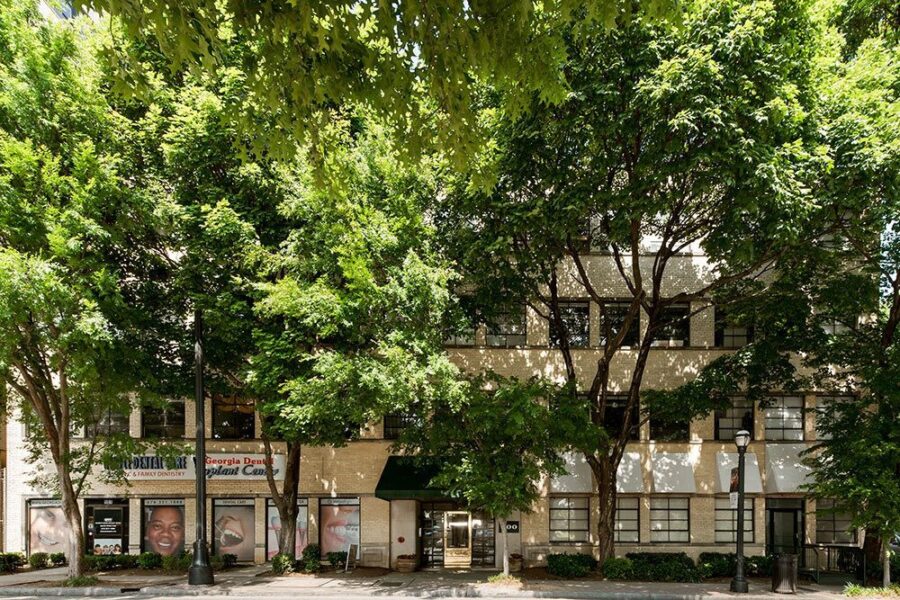 brick building with large trees and street lights next to it