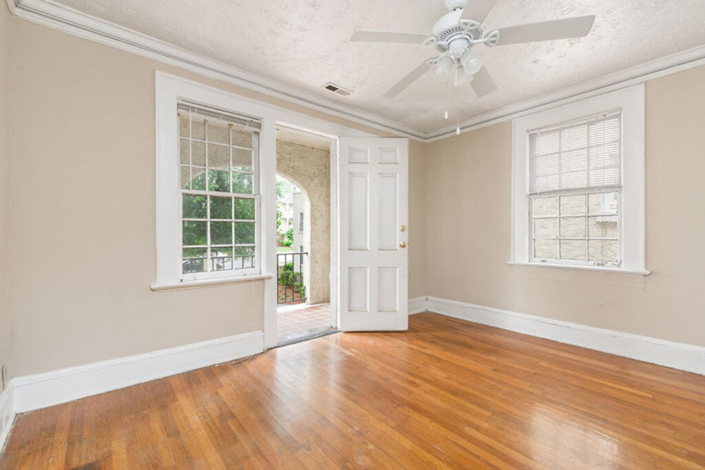 a living room with wood floors and a ceiling fan