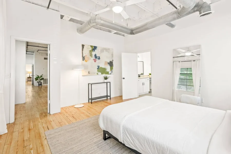 large bedroom with wood floors and natural light