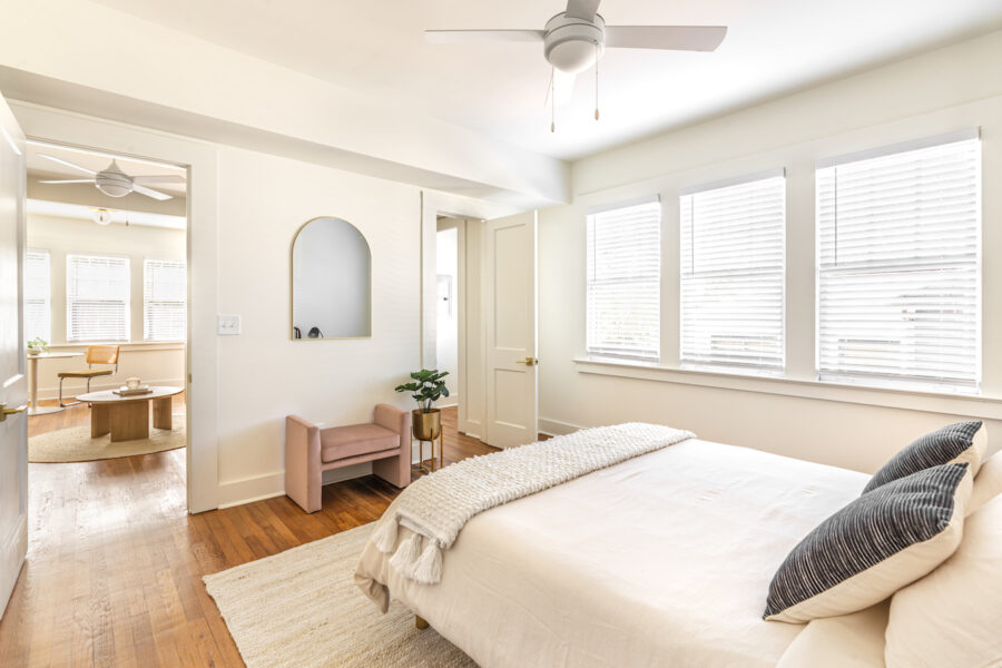 a bedroom with wood floors and lots of natural light